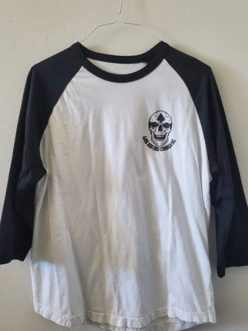 A white and black shirt with a skull on it